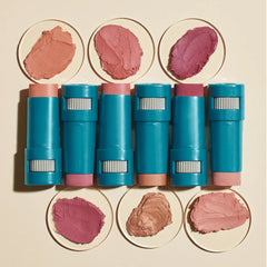 Lineup of blue cosmetic sticks with color swatches.