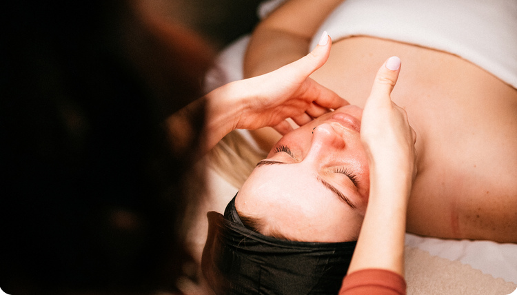 Women performing a facial massage during a facial treatment.
