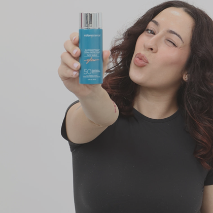 Women holding a bottle of Sunforgettable Total Protection Flex Glow.